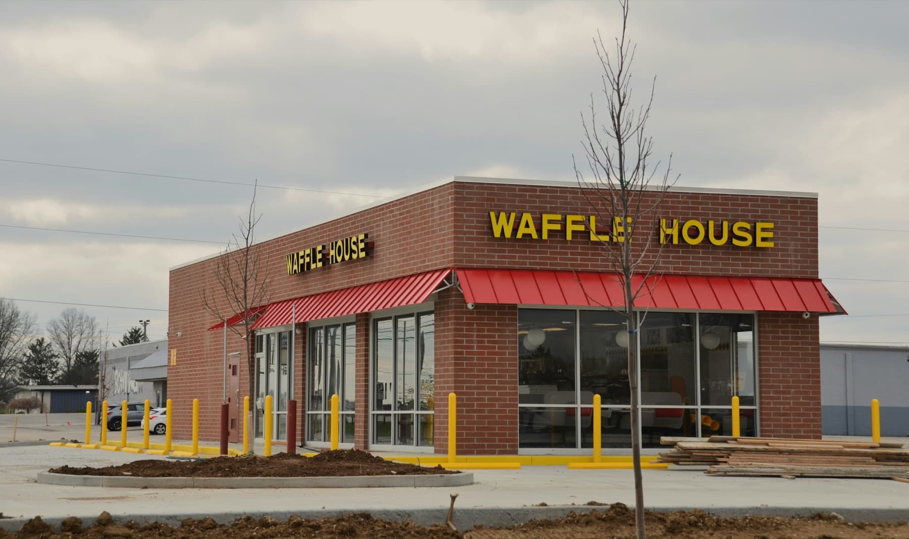 A brick Waffle House pad building with red awnings